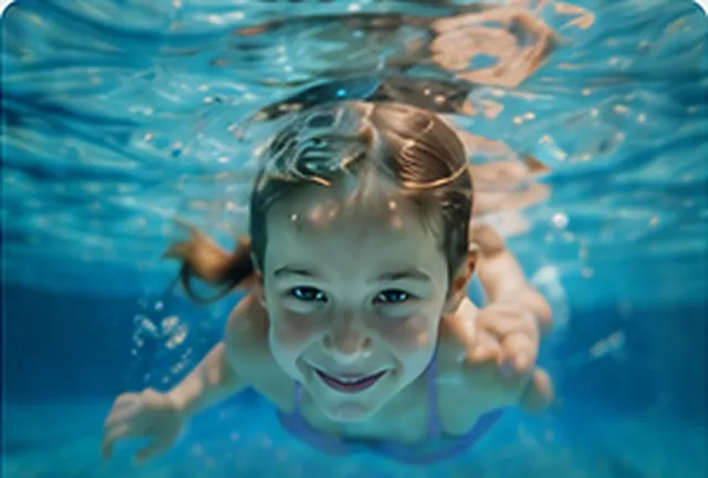 Mädchen schwimmt selbstbewusst unter Wasser