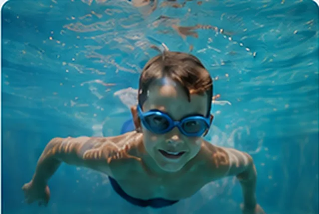 Junge mit Schwimmbrille übt unter Wasser
